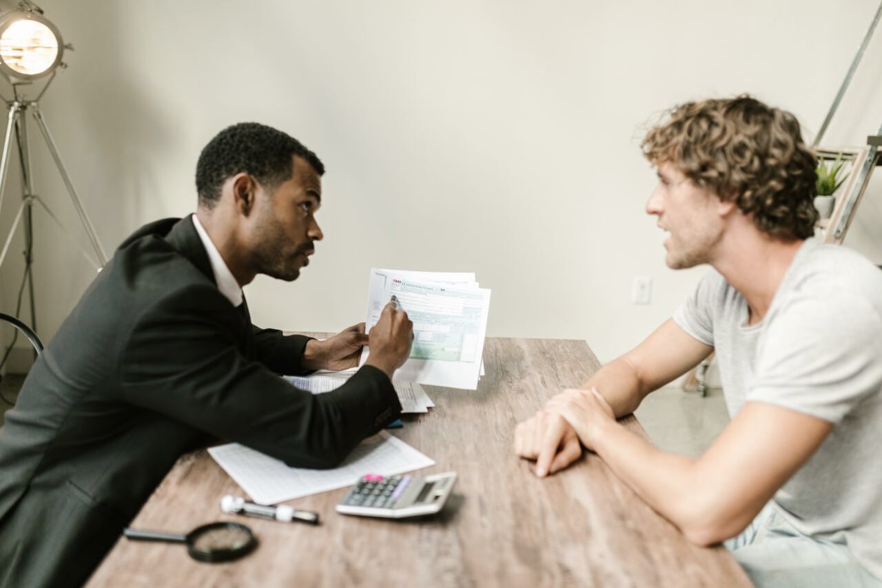 An advisor reviewing documents with a client across a desk