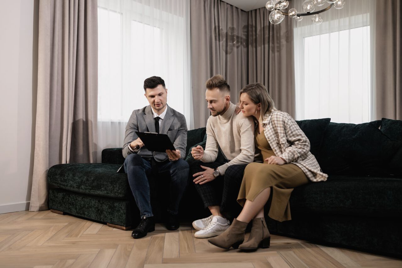 A real estate agent reviewing a home with a couple in the living room